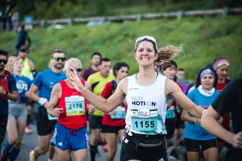 Corredora con camiseta de RunMotion en la salida de una carrera