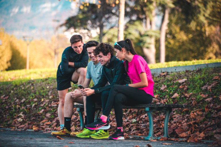 Corredores consultando la app RunMotion Coach en el móvil