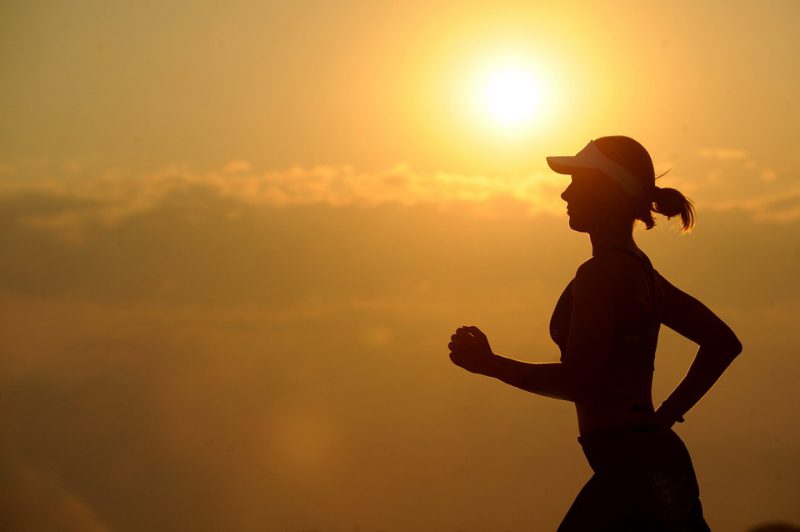 Corredor entrenando con calor extremo, siguiendo consejos clave para correr en canícula de forma segura.