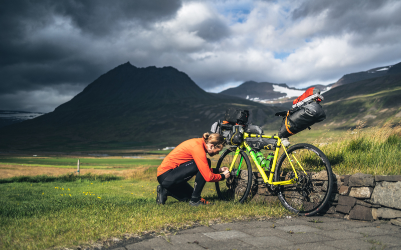 Ciclista elige bicicleta para bikepacking de principiantes, planificando ruta y material esencial.