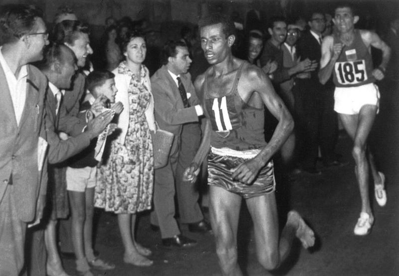 Abebe Bikila, maratonista descalzo, corriendo un maratón histórico en los Juegos Olímpicos.
