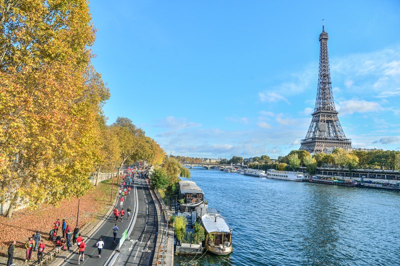 Corredores participan en el Ekiden de París, carrera de relevos de running en equipo.