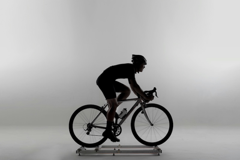 Triatleta ajustando su bicicleta en bike fitting para mejorar velocidad y comodidad.