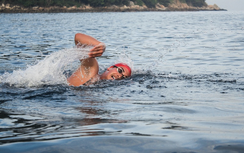 Triatleta nadando en aguas abiertas para superar el miedo y mejorar su confianza en competición.
