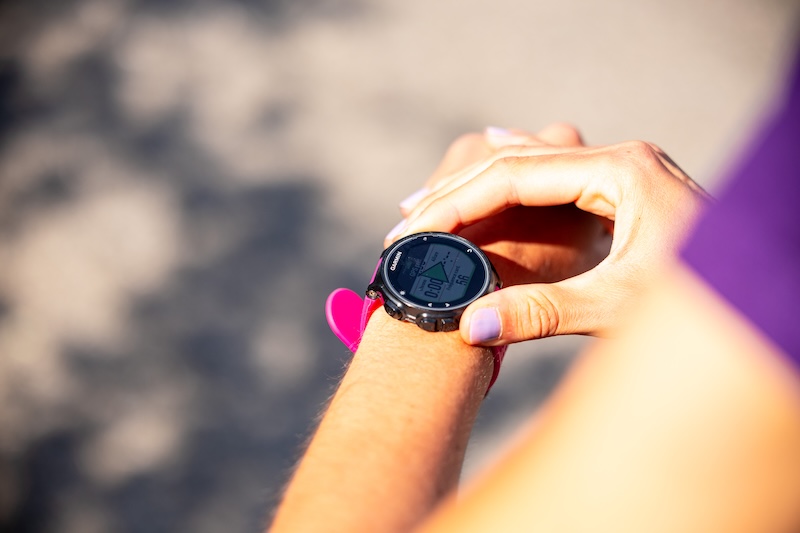 Corredor consulta un reloj GPS durante su preparación para completar su primer 10K