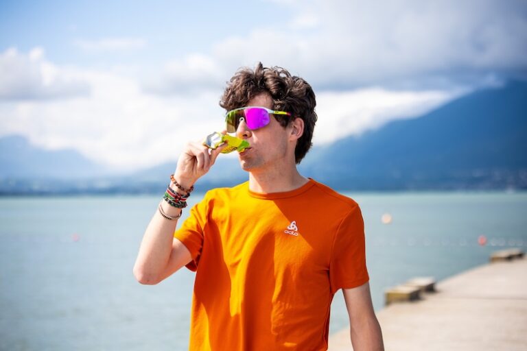 Corredor tomando un gel energético junto al lago
